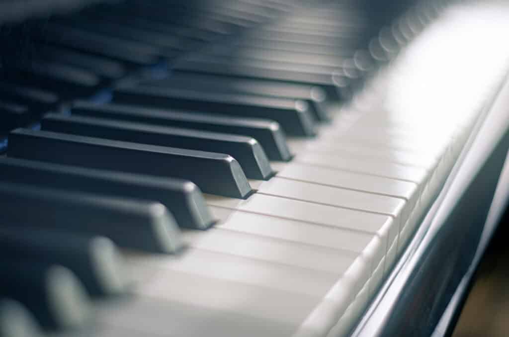 Clavier Piano Noir et Blanc Lumière Ambiance Clavier de piano numérique ou acoustique avec touches noires sombres et blanches lumineuses, effet bokeh subtil.